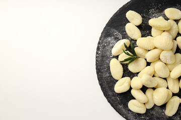 Tray with raw potato gnocchi on white background