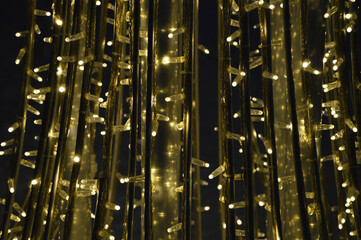 Obraz premium yellow street garland, decoration of the city on winter holidays. background for preparing for a Merry Christmas and a Happy New Year. brilliant lights.