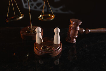 Obraz na płótnie Canvas Law and Justice. Vertical image of judge gavel, wooden figures and wedding rings