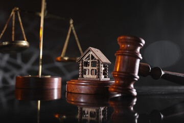 Obraz na płótnie Canvas Concept of suing for property. Wooden gavel with house close-up