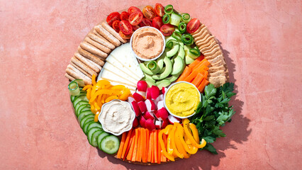 Colorful vegan Charcuterie board with raw vegetables and whole wheat snacks