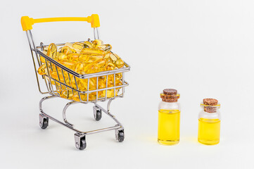 Omega 3 gelcapsules bij winkelkar. Gele vitamine, gezondheid eten op witte achtergrond. Dieetmedicijn.
