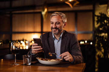 Confident caucasian man, arranging a meeting with his colleagues in a restaurant, over his phone.