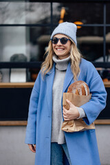 Portrait of smiling girl,  wearing sunglasses and cost, cold weather.