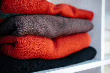 a lot of knitted things of different colors on white shelves