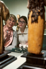 woman visitor with daughter looking to art in museum