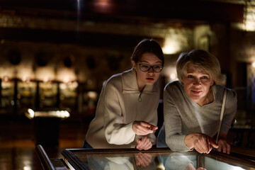 grandmother and granddaughter looking at medieval expositions in museum