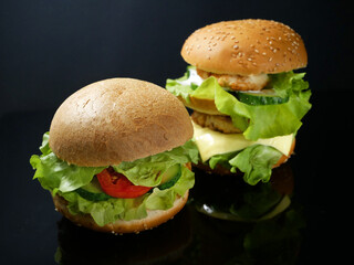 Two burgers with meat and vegan burger on black background