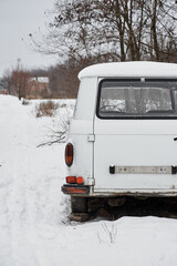 Abandoned retro car Barkas-Werke, back view in the forest in winter