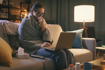 Sick woman with flu connecting with her laptop