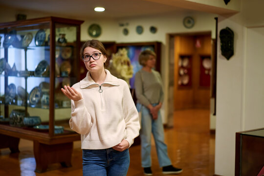 Attentive teenage girl exploring artworks in modern museum