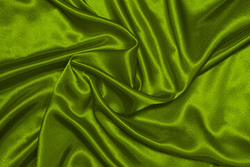 Texture of crumpled green olive satin fabric, beautiful pattern, top view.