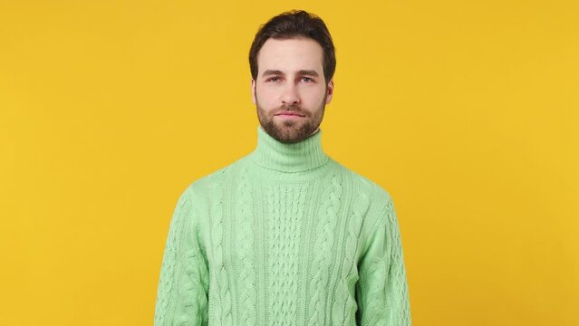 Tired young brunet bearded man 20s years old wears mint shirt did not get enough sleep last night after party and barely got up in the morning yawning isolated plain yellow background studio portrait