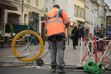 technician who installs optical fiber in the city center - obrazy, fototapety, plakaty