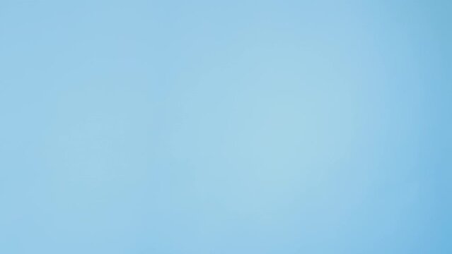 Waving greeting. Hi gesture. Saying hello. Happy nice teenager girl peeking out welcoming salute hand isolated on blue empty space ad background.