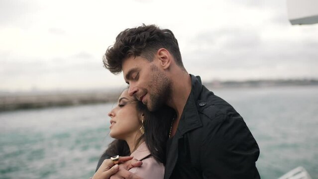 man hugging a girl on a yacht in cloudy weather