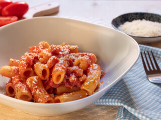 dish of Amatriciana. Italian pasta recipe with tomato sauce, bacon and parmesan on top.Tomato sauce...