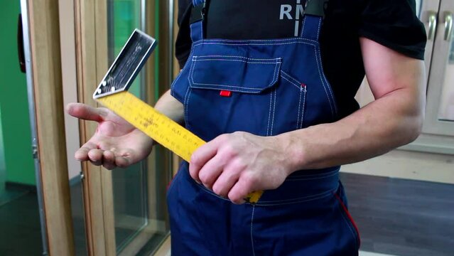 Square tool in hands of professional worker man. Try Square instrument, building and carpenter equipment. Construction, projecting, planning indoors, male job with L square. DIY building close up.