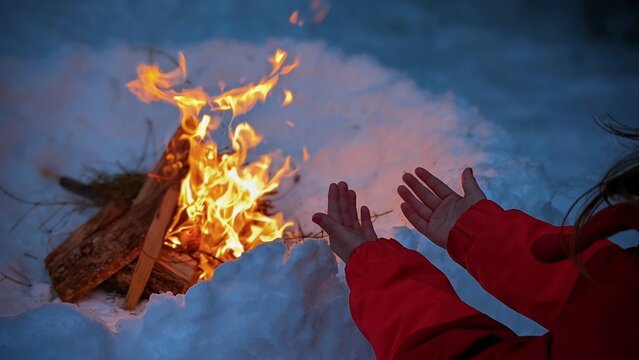 H&auml;nde w&auml;rmen sich am Feuer