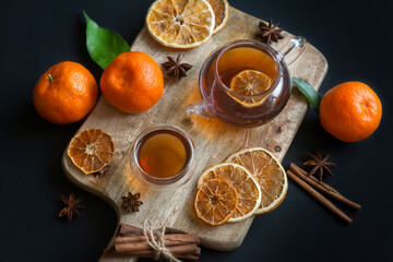 New Year and Christmas composition. Cup of tea, tangerines, christmas cookies, gingerbread on a wooden board close-up.
