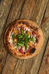 Pizza Caesar. Pizza with chicken, tomato, cheese and lettuce on wooden board. Top view. Free space for your text. Delivery food