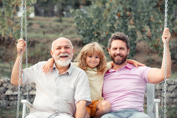 Male generation family together with three different generations ages grandfather father and son...