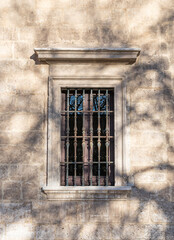 Ventana con barrotes de hierro forjado en el palacio de santa cruz en Valladolid, España