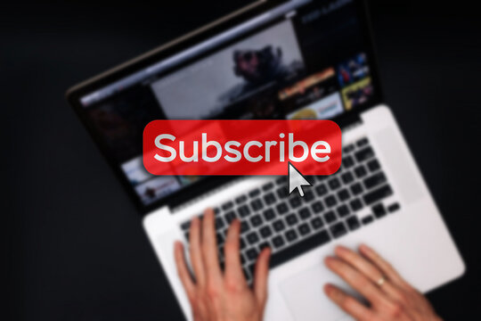 Subscription plan. Red online video subscribe button. Internet service on laptop digital tablet blured technology background. Visual contents concept. Social networking service.