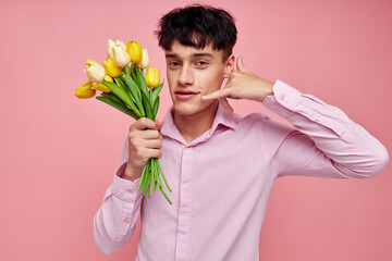 portrait of a young man bouquet of flowers date romance posing pink background unaltered