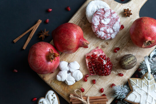 Pomegranate fruits and pomegranate cookies for Jewish holiday Rosh Hashanah on wooden background with copy space.
