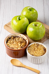 Apple crumble in ramekin on the table.