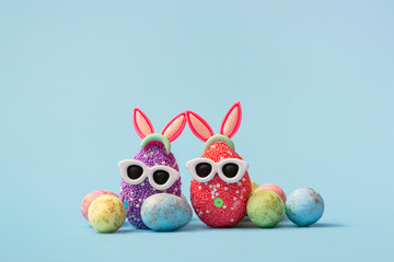 Colorful Easter egg with bunny ears and sunglasses on a blue background. Sale banner, mockup template. copy space