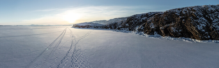 Beautiful landscape of winter snow-covered Lake Baikal and the surrounding mountains. Bird's-eye view