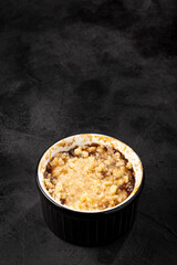 Apple crumble in ramekin on the table.