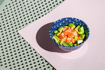 Poke bowl with rice, avocado, edamame beans and smoked salmon. Hard light, deep shadow