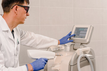 Male cosmetologist looking on Harmony XL screen after facial treatment procedure