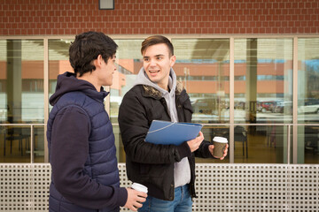 two college student boys walking with cup of coffee in hand
