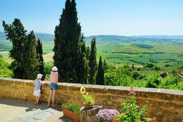 Two sisters admiring the view of green fields and farmlands with small villages on the horizon....