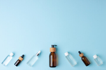 Cosmetic skin care products on blue background. Flat lay, copy space