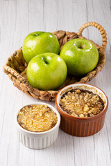 Apple crumble in ramekin on the table.
