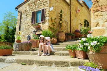 Fototapeta premium Young sisters exploring in Pienza, a village located in the beautiful Tuscany valley, known as the 'ideal city of the Renaissance' and a 'capital' of pecorino cheese.