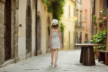 Young girl exploring medieval streets of picturesque resort town Bolsena, situated on the shores of Italy's largest lake, Lago Bolsena, Italy.