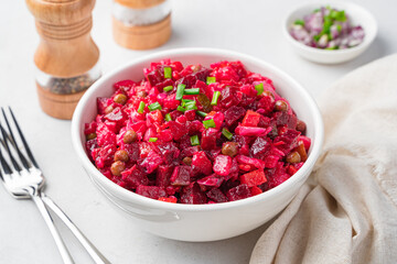 Beetroot salad, vinaigrette with vegetables close-up on a gray background.