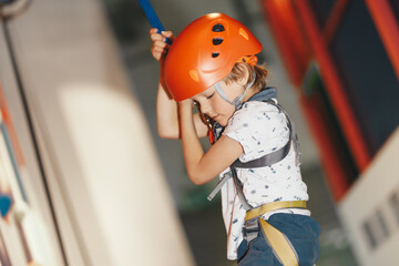 Mountain climbing class for kids. Young boy practicing rock climbing indoor. Indoor rock climbing...