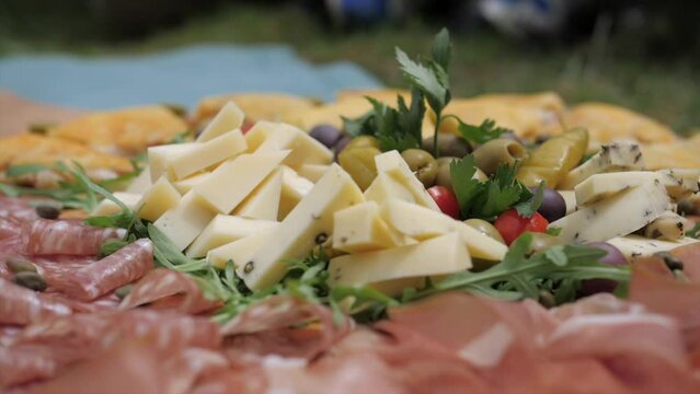 tasty local cheese, olives, prosciutto, salami and porridge presented on wooden platter, slider