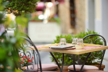 Empty restaurant table in medieval street of Montalcino town, located on top of a hill top and surrounded by vineyards, known worldwide for the production of wine. Tuscany, Italy.