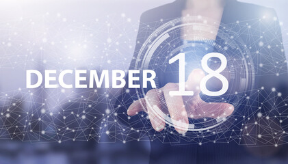 Fototapeta na wymiar December 18th. Day 18 of month, Calendar date. Hand click luminous hologram calendar date on light blue town background. Winter month, day of the year concept.