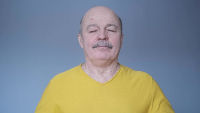 Senior hispanic man relaxing with closed eyes breathing deeply.