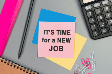 IT'S TIME FOR A NEW JOB - text on sticky note. Top view image of pink card, pencil, calculator and with many paper clips on table. Flat lay design