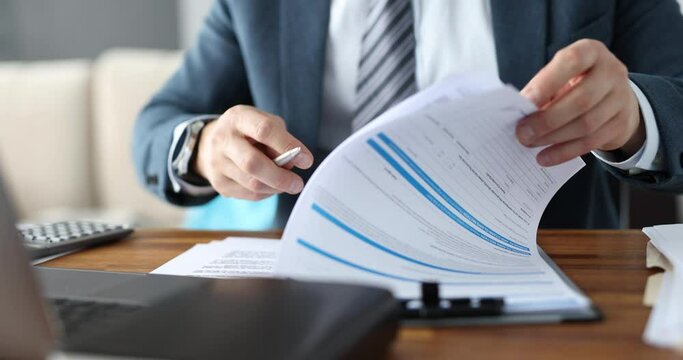 Businessman is studying business document at workplace closeup